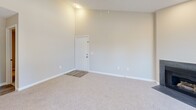 Located at 4129 Hearthside Dr in Wilmington, NC, this single-floor, 4-bedroom, 2-bathroom home offers a well-designed layout with a bright, open feel. The combined living and dining area is a standout feature, boasting vaulted ceilings, a ceiling fan, plush carpet, and large sliding glass doors that open onto one of two balconies, flooding the space with natural light and offering pleasant outdoor views of surrounding greenery. A fireplace adds warmth and character to the living area.

The kitchen is thoughtfully designed with white shaker cabinets, granite-style countertops, stainless steel appliances including a range, microwave, and refrigerator, and a breakfast bar peninsula that connects seamlessly to the dining and living spaces. Light wood-look flooring runs through the kitchen and dining areas, complementing the neutral color palette throughout.

Each of the four bedrooms features soft carpet, ceiling fans, and closets, providing comfortable and functional spaces. The primary bathroom includes a double vanity with a white countertop, framed mirror, and wood-look flooring, while the second bathroom offers a full soaking tub. A dedicated laundry area and utility room add practical convenience to this well-appointed home.