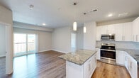 Located at 3100 Technology Blvd W in Bozeman, Montana, this well-appointed 2-bedroom, 2-bathroom residence offers a thoughtfully designed open-concept layout with clean, modern finishes throughout. Wood-style flooring flows seamlessly across the entire living space, contributing to a warm and cohesive aesthetic.

The kitchen is a standout feature, showcasing white shaker cabinetry, a subway tile backsplash, granite countertops, and a full suite of stainless steel appliances including a range, microwave, dishwasher, and refrigerator. A central island with matching granite provides additional prep space and is highlighted by elegant pendant lighting above.

The open living area connects directly to the kitchen and includes access to a private balcony, allowing for natural light and outdoor views. The spacious primary bedroom features a ceiling fan, a large window with outdoor views, and direct access to a well-sized walk-in closet with wire shelving. The en-suite primary bathroom offers a granite vanity with an undermount sink and white cabinetry. A second bedroom and additional full bathroom provide comfortable accommodations for guests or residents. The neutral color palette and consistent finishes throughout lend the space a clean, move-in-ready feel.