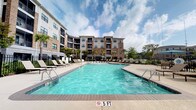 Located at 1201 Central Haven Dr in Mount Pleasant, South Carolina, this outdoor amenity space offers a well-appointed resort-style experience designed for relaxation and community gathering. The centerpiece is a generously sized swimming pool with crystal-clear turquoise water, framed by a wide pool deck lined with lounge chairs — ideal for enjoying the South Carolina sunshine. The surrounding multi-story residential buildings, finished in a combination of brick and siding, provide an attractive architectural backdrop that defines the courtyard-style layout.

Adjacent to the pool is a covered outdoor lounge pavilion that serves as a social hub for residents. Supported by classic white columns with brick bases, the pavilion features a wood-burning brick fireplace as its focal point, flanked by built-in seating with decorative tile accents. Ceiling fans overhead ensure comfortable airflow in warmer months, while wall-mounted lighting and a flat-screen television make it a versatile space for both daytime lounging and evening gatherings. The open-air design allows for seamless views of the surrounding greenery and pool area, creating a cohesive and inviting outdoor environment that reflects the relaxed coastal lifestyle of the Mount Pleasant area.
