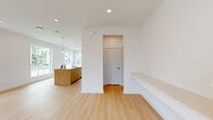 Located on Bald Eagle Lane in Frisco, TX, this modern two-story home offers four bedrooms and three bathrooms thoughtfully distributed across two well-proportioned floors. The main level features an open-concept kitchen and living area bathed in natural light from large picture windows overlooking the neighborhood. The kitchen is anchored by a generous wood-toned island with a built-in sink, complemented by pendant lighting and light hardwood-style flooring that flows seamlessly throughout the main living spaces. A light-filled entryway with a glass-paneled front door and built-in bench leads to a staircase connecting both levels. The main floor also includes a dedicated laundry room equipped with a washer, dryer, utility sink, and overhead shelving for added convenience. The attached two-car garage provides ample parking and storage space. Upstairs, the primary bedroom features a tray ceiling, ceiling fan, and multiple windows with neighborhood views, alongside a walk-in closet with wire shelving. Additional bedrooms are carpeted and fitted with ceiling fans. The bathrooms are clean and contemporary, featuring white cabinetry with brushed gold hardware and tub-shower combinations with subway tile surrounds. Outside, a low-maintenance artificial turf backyard with a concrete patio and wrought iron fencing completes this well-appointed home.