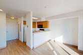 This studio in Revere, MA offers a well-designed, single-floor layout that efficiently combines the living, dining, and kitchen areas into one cohesive open-plan space. Light wood-tone flooring runs throughout, lending warmth and visual continuity to the interior. Bright white walls and abundant natural light enhance the sense of openness throughout.

The living area is anchored by a large sliding glass door that opens onto a private balcony, offering impressive views of the water and surrounding landscape — a standout feature of this space. The balcony brings in generous sunlight, making the living area feel airy and connected to the outdoors.

The kitchen is defined by a peninsular breakfast bar that provides a natural separation from the living area. Warm honey-toned cabinetry lines the walls, complemented by light countertops, a stainless steel sink, a full-size refrigerator, an electric range with an over-the-range microwave, and ample upper and lower cabinet storage.

The bathroom is clean and practical, featuring a full soaking tub with a shower, chrome fixtures, a vanity with matching wood cabinetry, and a light countertop. A dedicated closet provides additional storage. The overall ambiance of this studio is bright, functional, and well-appointed, with the water-view balcony serving as its most compelling feature.