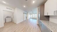 Located on Blanding Blvd in Jacksonville, FL, this thoughtfully designed single-story, one-bedroom, one-bathroom unit offers a clean, modern aesthetic throughout. The exterior presents a fresh, contemporary look with gray lap siding, large windows, and neatly landscaped grounds accented by young palm trees.

Inside, light-toned luxury vinyl plank flooring flows throughout the entire unit, lending a cohesive and airy feel. The open-concept living area seamlessly connects the kitchen, dining, and living spaces, all bathed in natural light from large windows and served by a ceiling fan overhead. A stylish sliding barn door adds a distinctive architectural touch.

The kitchen is well-appointed with two-tone gray and white cabinetry, granite-look countertops, stainless steel appliances including a refrigerator, range, microwave, and dishwasher, plus an undermount sink.

The bedroom is a comfortable, light-filled retreat with a ceiling fan and a window with outdoor views, alongside a walk-in closet with built-in wire shelving for organized storage. The bathroom features a full tub-shower combo with white subway tile surround and a gray vanity with stone-look countertop.

A dedicated laundry area houses a full-size washer and dryer, and the unit also includes a private patio for outdoor enjoyment.