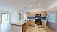 Located at 1700 Connery Ct in Garner, NC, this well-designed one-bedroom, one-bathroom residence offers a smart, functional layout making excellent use of its space. Light wood-style flooring runs throughout the main living areas, creating a warm and cohesive aesthetic.

The open-concept kitchen is a standout feature, showcasing natural wood cabinetry, granite countertops, a blue subway tile backsplash, and a full suite of stainless steel appliances including a range, microwave, dishwasher, and refrigerator. A peninsula with a double basin sink and pendant lighting above anchors the kitchen and opens naturally to the living area. In-unit washer and dryer hookups are conveniently tucked nearby behind a closeted nook.

The bedroom is a comfortable, well-lit retreat with plush carpeting, a ceiling fan, and a window that invites natural light. An adjoining walk-in closet provides generous storage with wire shelving. The bathroom is clean and modern, featuring a wood-toned vanity with a granite countertop and a bold-framed mirror, complemented by matching light wood flooring.

A glass-panel exterior door in the living area adds additional natural light and provides easy outdoor access, completing this thoughtfully designed home.