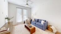 Located at 7733 Burleson Road in Austin, TX, this single-story, one-bedroom, one-bathroom unit offers a thoughtfully designed open-concept layout that maximizes its efficient footprint. Light wood-style flooring flows throughout the main living areas, creating a warm and cohesive aesthetic.

The living room is bright and inviting, featuring a ceiling fan, clean white walls, and a glass-paneled door that fills the space with natural light and provides direct access to the outside. The kitchen is outfitted with white shaker cabinetry, a white quartz peninsula with an undermount sink, stainless steel appliances including a refrigerator, range, and microwave, and recessed lighting accented by a gold pendant fixture — offering both style and functionality.

The bedroom is a comfortable retreat with plush carpet flooring, a ceiling fan, and a large window fitted with horizontal blinds that allow for natural light and privacy. A dedicated closet and an in-unit stacked washer and dryer add practical convenience.

The bathroom is clean and modern, featuring light wood-style flooring, white cabinetry, and a shower-tub combination. The layout connects directly to the bedroom, enhancing the sense of a private, cohesive living space. Overall, the unit presents a contemporary, move-in-ready design with a neutral palette throughout.