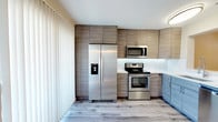 Located at 500 Northside Circle in Atlanta, Georgia, this thoughtfully updated single-floor residence offers a clean, modern aesthetic with quality finishes in every room. The open living area is bright and inviting, featuring warm-toned hardwood-style flooring, recessed lighting, and neutral gray walls that create a versatile backdrop. A charming arched built-in shelving nook adds architectural character, while a window with blinds brings in natural light.

The kitchen is a standout feature, outfitted with a full suite of stainless steel Whirlpool appliances — including a side-by-side refrigerator with ice and water dispenser, electric range, over-the-range microwave, and dishwasher. Two-tone cabinetry in warm taupe and cool blue-gray tones pairs beautifully with white quartz countertops and a classic white subway tile backsplash. A stainless steel undermount sink and modern faucet complete the space.

The bedroom features cool-toned hardwood-style flooring and a ceiling fan with integrated lighting. The hallway provides convenient access to closet and utility storage. Bathrooms are finished with marble-look tile flooring, white subway tile tub surrounds, and clean white fixtures, delivering a crisp, spa-like atmosphere throughout.