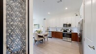 Located at 328 Cherokee Blvd in Chattanooga's vibrant North Shore neighborhood, this single-floor residence offers a thoughtfully designed open layout with modern finishes throughout. The kitchen is a standout feature, showcasing a two-tone cabinetry design with rich walnut lower cabinets paired with crisp white upper cabinets extending to the ceiling, complemented by a classic subway tile backsplash, white quartz countertops, and stainless steel appliances. Light hardwood-style flooring flows seamlessly from the kitchen into the adjacent dining area, creating a cohesive and airy feel. The living room is bright and inviting, anchored by large sliding glass doors that provide direct balcony access and generous views of the surrounding streetscape and greenery, flooding the space with natural light. The bedroom is a calm retreat, featuring plush carpeting, a ceiling fan, and a window that allows natural light and outdoor views. The bathroom is finished in clean, neutral tones with white cabinetry, a large vanity mirror, and tile flooring. A dedicated laundry area with a full-size washer and dryer adds everyday convenience, while an additional closet provides practical storage. The overall ambiance is clean, contemporary, and comfortable throughout.