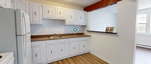 This well-designed apartment maximizes its 57 square meter floor plan, offering a comfortable living space with two bedrooms and one bathroom. The primary bedroom, measuring 13 square meters, provides ample space for relaxation. Throughout the apartment, hardwood floors add warmth and elegance, complemented by crisp white walls that create a bright, airy atmosphere.

The kitchen showcases white cabinetry with contrasting dark handles, wooden countertops, and a full-sized refrigerator, balancing functionality with style. A charming detail is the exposed wooden beam, adding character to the space. The bathroom features a tiled shower-tub combination with multi-colored slate-like tiles, creating a spa-like ambiance.

Large windows in the bedrooms and living areas flood the space with natural light, enhancing the open feel of the apartment. Baseboard heating ensures comfort year-round. The layout, as seen in the 3D floor plan, reveals a thoughtful design that maximizes space efficiency while maintaining a sense of openness. Located at V488 - 87 Vanier, this apartment offers a blend of modern amenities and practical living space.