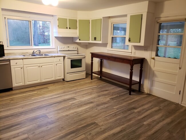 Large eat-in kitchen has new vinyl flooring and door to the covered patio. - 10106 Wingfield Rd