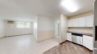 Located at 1701 Elm St SE in Minneapolis, MN, this two-bedroom, one-bathroom unit offers a practical and well-organized single-floor layout. The kitchen is fully equipped with stainless steel appliances — including a refrigerator, range, microwave, and dishwasher — complemented by white cabinetry, dark countertops, and wood-look tile flooring that adds warmth to the space. Tile wainscoting lines the transition area between the kitchen and living space, adding a clean, durable touch.

The living area features light-toned tile flooring, a textured ceiling, and a window that brings in natural light. Baseboard heating is present throughout the unit, ensuring consistent warmth. The primary bedroom is a comfortable size, offering a sliding-door closet and a ceiling fan with light fixture. The second bedroom also includes a window with blinds and baseboard heating, providing a bright and functional space. Both bedrooms feature neutral wall tones and tile flooring.

The bathroom is neatly appointed with white cabinetry, a dark countertop vanity, a large mirror, and full tile walls in the shower area, creating a clean and cohesive look. Overall, the unit presents a functional, well-maintained interior with consistent neutral finishes ideal for everyday living.