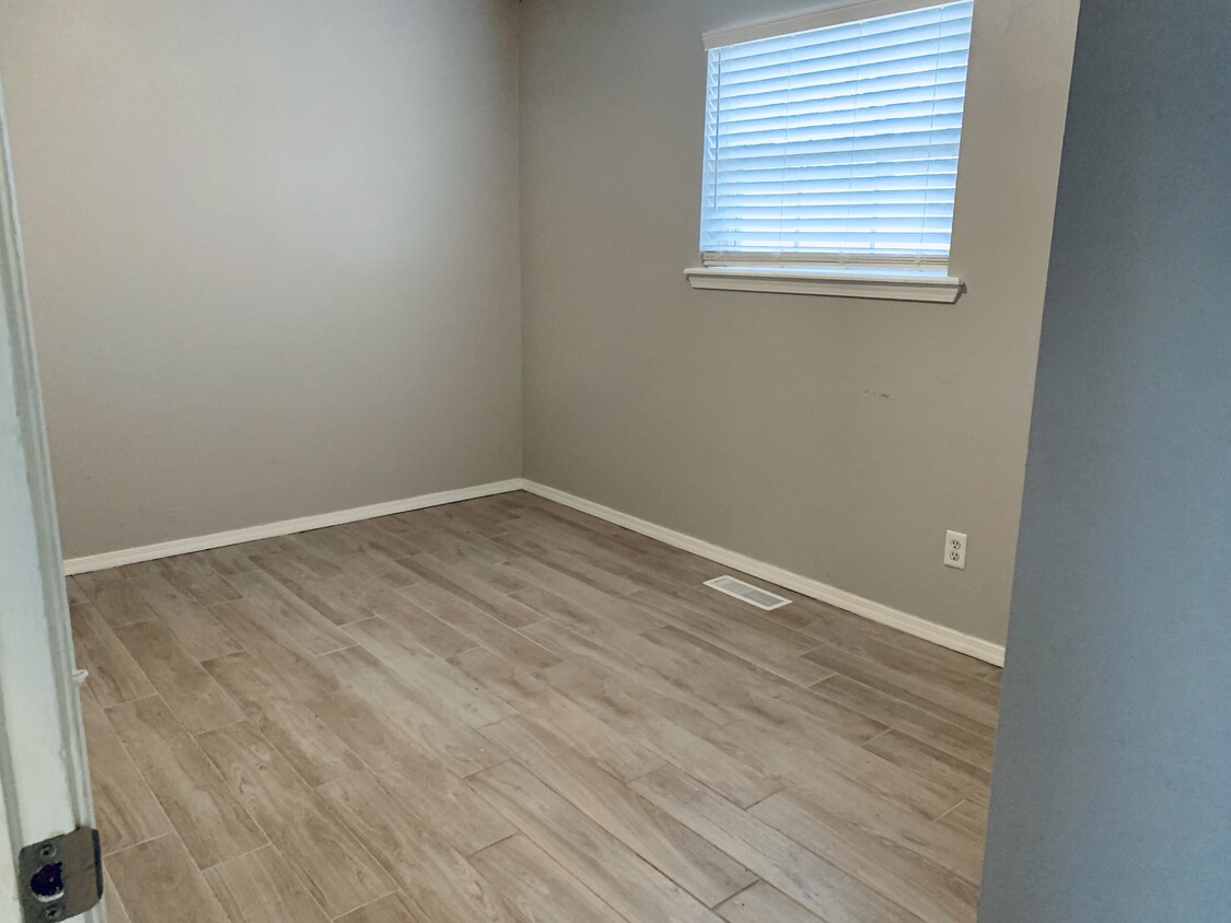 Newly renovated guest room with grey walls and beautiful grey porcelain wood plank tile. - 104 E Knoxville St