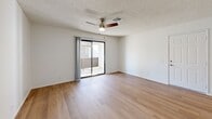 Located at 81955 Hoover Ave, Unit 28 in Indio, CA, this single-floor 2-bedroom, 2-bathroom unit offers a clean, functional layout designed for comfortable living. Light wood-style flooring runs throughout, creating a bright and cohesive look across every room. The open living room features a ceiling fan and a sliding glass door that leads to a private balcony, filling the space with natural light and providing easy outdoor access. An adjacent dining area connects seamlessly to the galley-style kitchen, which is outfitted with white cabinetry, light countertops, a gas range, and recessed lighting — offering ample storage and prep space in an efficient corridor layout. The primary bedroom is generously sized, featuring a ceiling fan and a sliding closet. The second bedroom includes a closet and a window with outdoor views. Both bathrooms are finished with light wood flooring, white surrounds, tub-shower combinations, and brushed nickel fixtures. Three total closets and a dedicated utility room provide practical storage throughout. Textured ceilings are present in all rooms, and the consistent white walls contribute to a clean, neutral palette throughout this well-maintained unit.
