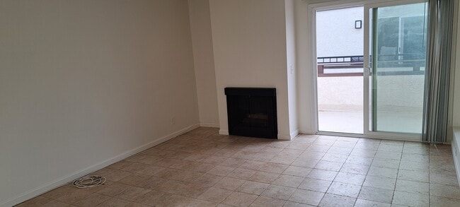LIVING ROOM WITH FIREPLACE AND SLIDER TO BALCONY, TRAVERTINE STYLE PORCELAIN TILES - 314 20th St
