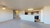 Located at 8060 North Crown Pointe Street in Post Falls, Idaho, this single-floor residence offers a well-designed, open-concept layout that connects the living and kitchen areas seamlessly. The spacious living room is finished with neutral-toned carpet and receives natural light through a large sliding glass door that opens to an outdoor area, framing views of the surrounding landscape. A second window further brightens the room, enhancing the airy feel of the space.

The kitchen is outfitted with rich dark wood cabinetry, light-colored countertops, and a full suite of black appliances including a refrigerator, electric range, built-in microwave, and dishwasher. Wood-look flooring ties the kitchen together, and a peninsula with an integrated sink provides additional workspace and a natural division from the living area. Notably, the kitchen also accommodates a dedicated in-unit washer and dryer.

The bedrooms are carpeted and generously sized, each offering closet access and natural light through sliding or standard windows. The primary bathroom features a dual-sink vanity with dark cabinetry and a broad mirror, while a secondary bathroom includes a full tub-shower combo and wood-look tile flooring. The overall design is clean and functional, with a neutral palette throughout.