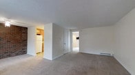 This 1-bedroom, 1-bathroom unit is designed with a straightforward, efficient layout that maximizes every square foot of available space. The living area features neutral-toned wall-to-wall carpeting that adds warmth underfoot, while the textured ceiling and clean white walls create a bright, airy atmosphere throughout. A baseboard heating system ensures consistent comfort year-round. The kitchen is thoughtfully separated from the living space, offering wood-toned cabinetry and white appliances, including a full-sized refrigerator, providing a practical cooking environment. A closet off the main living area offers convenient additional storage. The bedroom, accessible through a doorway from the main living space, continues the neutral aesthetic with consistent flooring and ample room for furnishings. The unit's single-floor layout ensures easy accessibility, with all spaces flowing naturally from one to the next. Overall, the unit presents a clean, move-in ready environment with a simple and cohesive design palette, well-suited for those seeking a comfortable, low-maintenance living space.