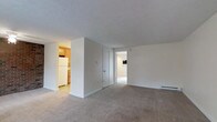 This 1-bedroom, 1-bathroom unit is designed with a straightforward, efficient layout that maximizes every square foot of available space. The living area features neutral-toned wall-to-wall carpeting that adds warmth underfoot, while the textured ceiling and clean white walls create a bright, airy atmosphere throughout. A baseboard heating system ensures consistent comfort year-round. The kitchen is thoughtfully separated from the living space, offering wood-toned cabinetry and white appliances, including a full-sized refrigerator, providing a practical cooking environment. A closet off the main living area offers convenient additional storage. The bedroom, accessible through a doorway from the main living space, continues the neutral aesthetic with consistent flooring and ample room for furnishings. The unit's single-floor layout ensures easy accessibility, with all spaces flowing naturally from one to the next. Overall, the unit presents a clean, move-in ready environment with a simple and cohesive design palette, well-suited for those seeking a comfortable, low-maintenance living space.
