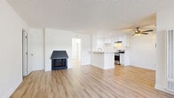 Located at 2600 W La Habra Blvd in La Habra, California, this single-floor, one-bedroom, one-bathroom residence offers a clean, modern aesthetic throughout. Light-toned luxury vinyl plank flooring runs seamlessly across the entire unit, creating a bright and cohesive feel.

The open-concept living and kitchen area serves as the heart of the home. The living room is anchored by a striking fireplace with a bold dark surround, adding character to the otherwise crisp white interior. Large windows allow natural light to fill the space, with a sliding glass door leading to a private patio. The kitchen features white shaker-style cabinetry, subway tile backsplash, a peninsula with a sink, stainless steel range, recessed lighting, and a ceiling fan — making it both functional and stylish.

The bedroom is a comfortable, well-lit retreat with a ceiling fan, a wide window with natural light, and a mirrored closet. The unit includes three closets in total, offering generous storage throughout. The bathroom is finished with a white shaker vanity, brushed nickel fixtures, a backlit mirror, and tile surround.

The textured ceilings and consistent white walls throughout create a clean, move-in-ready environment suited for comfortable everyday living.
