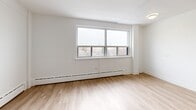 Located at 2 Regal Rd in Toronto's vibrant Dovercourt-Wallace Emerson neighbourhood, this well-appointed one-bedroom, one-bathroom unit offers a clean, modern aesthetic throughout. Light wood laminate flooring flows seamlessly across the entire space, creating a warm and cohesive feel.

The open-concept kitchen and living area serves as the heart of the unit. The kitchen is outfitted with crisp white cabinetry, dark countertops, a subway tile backsplash, stainless steel appliances including a full-size refrigerator and microwave, and a peninsula island that provides additional prep space and a natural division between the kitchen and the generous living area.

The bedroom is a comfortable size, featuring large windows that invite natural light and offer views of the surrounding neighbourhood. Baseboard heating runs along the walls, and a mirrored sliding closet adds both storage and a sense of openness to the room.

The bathroom is finished with classic white subway tile surrounding a full soaking tub and shower, complemented by a dark wood vanity and a wall-mounted mirror, creating a timeless and clean look.

A hallway connects the main living areas with the bathroom and bedroom, keeping the layout practical and well-organized. Throughout the unit, white walls and bright finishes contribute to an airy, light-filled atmosphere.
