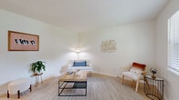 Located at 4309 Scovel Ave in Pascagoula, Mississippi, this well-appointed single-floor home offers a thoughtfully organized layout across one bedroom, one bathroom, and two closets. The living room is bright and airy, finished with light-toned flooring, crisp white walls, and natural light filtering through window blinds — creating a welcoming, open atmosphere. The combined dining room and kitchen area features tile flooring, a ceiling fan with light fixture, and a pass-through window connecting the dining space to the kitchen. The kitchen is equipped with white cabinetry, a black sink fixture, and stainless steel appliances including a range, microwave, and refrigerator. The spacious primary bedroom includes light hardwood-style flooring, a ceiling fan, and natural light from a window, accompanied by two closets that provide generous storage. The bathroom is cleanly finished with tile flooring, white subway tile wainscoting, a gray vanity with black hardware, a round mirror, and a full shower-tub combination. Throughout the home, the consistent use of white walls, neutral tones, and natural light creates a cohesive, calm aesthetic well-suited to comfortable everyday living.