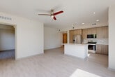 Located at 425 Centerpointe Circle in Altamonte Springs, FL, this well-appointed three-bedroom, two-bathroom residence offers a thoughtfully designed single-floor layout with generous living space. The open-concept living, dining, and kitchen area serves as the heart of the home, featuring light wood-look flooring, recessed lighting, and a ceiling fan that enhances the airy atmosphere. The kitchen is outfitted with warm-toned flat-panel cabinetry, white quartz countertops, a textured tile backsplash, stainless steel appliances, and a central island — ideal for cooking and entertaining. Large sliding glass doors in the primary bedroom flood the space with natural light and open directly onto a private balcony with glass railings, offering picturesque views of mature trees, green lawns, and the surrounding skyline. Each bedroom features light flooring, ceiling fans, and ample closet space. The bathrooms are finished with marble-look tile flooring, wood-grain vanities, and well-lit mirrors. A dedicated laundry room and a connecting hallway complete the functional layout, making this residence as practical as it is stylish.