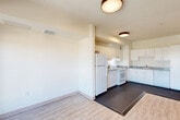 Located at 2905 Santa Rosa Ave in Santa Rosa, CA, this single-floor, 3-bedroom, 2-bathroom residence offers a practical and well-organized layout. The open-concept living, dining, and kitchen area forms the heart of the home, featuring light wood-style flooring that transitions seamlessly into the kitchen's durable dark vinyl flooring. The kitchen is equipped with ample white cabinetry, granite-style countertops, a full-size refrigerator, and a range with overhead ventilation, providing generous storage and prep space. Natural light flows in through large windows and a glass-panel door leading to a private balcony, offering outdoor views of the surrounding neighborhood. The three bedrooms are carpeted for comfort, with the generously sized primary bedroom offering notable square footage. Four closets throughout the unit provide abundant storage, including walk-in style closets with wire shelving systems. Both bathrooms feature light vinyl flooring, a tub-shower combination with tiled surrounds, pedestal sinks, wall-mounted storage cabinets, and a clean, bright aesthetic. A hallway connects the bedrooms and bathrooms, contributing to an efficient and cohesive floor plan throughout the home.