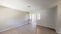 Located at 44710 Division Street in Lancaster, CA, this single-story 2-bedroom, 2-bathroom home offers a practical and comfortable layout. The interior is finished with neutral gray and beige tones throughout, complemented by wood-look laminate flooring in the main living areas and plush carpet in the bedrooms. Textured ceilings are present throughout the home. The living room is an open, well-proportioned space that flows into the dining area, which features a ceiling fan with light fixture and a window fitted with vertical blinds for natural light. The kitchen is equipped with white cabinetry, a gas range, a range hood, a double-basin sink, and light wood-look flooring, with a window that brings in additional daylight. Both bedrooms are carpeted and receive natural light through windows with vertical or grid-style blinds. The primary bedroom includes a closet, and the home features a total of three closets for ample storage. Two hallways connect the rooms efficiently. The bathrooms are cleanly finished in white, one featuring a full tub/shower combo and the other a toilet and vanity, each with a small window for ventilation. The home's straightforward, functional design makes it a practical residence in the Lancaster area.