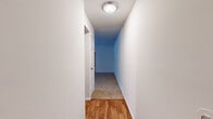 This single-floor residence in Catonsville, MD offers a well-organized layout with four bedrooms, two full bathrooms, a living room, kitchen, dedicated laundry room, and a connecting hallway. The living room is generously sized, featuring plush neutral carpeting and a large sliding glass door that fills the space with natural light and provides views of the exterior. The kitchen is thoughtfully equipped with warm oak cabinetry, granite-toned countertops, a black dishwasher, a full-size refrigerator, a built-in microwave, and a white range — all complemented by wood-look hardwood flooring that extends through the entryway and kitchen area. The four bedrooms are carpeted and offer clean, neutral walls; the primary bedroom is notably spacious, while the secondary bedrooms each feature windows that bring in natural light. Both bathrooms are efficiently designed, with one showcasing mosaic tile flooring, a wood-vanity with a white sink, a wall mirror with overhead lighting, and a shower-tub combo. The dedicated laundry room houses a full-size washer and dryer alongside upper cabinetry for added storage. A central hallway with overhead flush lighting connects the rooms, creating a cohesive and practical flow throughout the home.