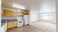 This single-story unit in Oakley, California offers a practical and well-organized layout designed for comfortable everyday living. The kitchen is equipped with light maple cabinetry, dark granite-style countertops, a white electric range, a refrigerator, a dishwasher, and a stainless steel sink — providing ample storage and prep space. Wood-style plank flooring runs through the kitchen and extends into the open living area, which is brightened by a window that allows natural light to fill the space. The living area transitions seamlessly from the kitchen, creating an open, connected feel ideal for daily use. The bedrooms feature neutral-toned carpet, white walls, and generous closet space — one bedroom includes mirrored sliding closet doors, adding both function and visual depth. The bathroom is clean and straightforward, finished with tile flooring, a wall-mounted sink, a medicine cabinet with mirror, and a shower-tub combination. Throughout the unit, the consistent use of light, neutral tones contributes to a bright and cohesive atmosphere. The floor plan, as seen in the 3D model, reveals a thoughtfully arranged layout that maximizes the use of available space across all rooms.