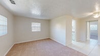 Located at 1939 Burkholder Cir E in Jacksonville, FL, this single-floor, one-bedroom, one-bathroom home offers a compact and efficient layout designed to maximize every square foot. The living room greets you at entry, featuring plush carpet flooring, a ceiling fan, and a window that allows natural light to brighten the space. The transition from carpet to light tile marks the path into the hallway and kitchen area. The galley-style kitchen is well-appointed with white cabinetry, laminate countertops, a tile backsplash, white appliances including a refrigerator and dishwasher, and a window providing additional natural light. The spacious bedroom offers generous proportions with soft carpet, two windows dressed with vertical blinds, a ceiling fan, and a full-width built-in closet complete with shelving and a built-in drawer unit for ample storage. The full bathroom features tile-surround walls, a tub-shower combination, a white vanity with mirror, and a window. Textured ceilings are consistent throughout the home, adding a subtle design element. This well-laid-out residence in Jacksonville provides comfortable, functional living in a single-story setting.