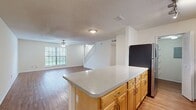 This modern townhome in Cambridge Woods offers 1,080 square feet of living space spread across two floors. The ground floor, measuring 560 square feet, features an open-concept design that seamlessly integrates the kitchen, living, and dining areas. The kitchen boasts honey-toned cabinetry, stainless steel appliances, and a practical galley layout with ample counter space.

Ascending to the 520-square-foot upper level, you'll find two generously sized bedrooms, including a primary suite spanning 170 square feet. Both bedrooms are equipped with ceiling fans and large windows, ensuring optimal comfort and natural light. The home includes 2.5 bathrooms, with at least one featuring a shower-tub combination adorned with crisp white tiles and a decorative blue tile accent.

Throughout the residence, warm-toned hardwood flooring creates a cohesive and inviting atmosphere. The neutral wall color scheme provides a blank canvas for personal decor preferences. Additional amenities include closet space in the bedrooms and a hallway for extra storage.

This townhome's thoughtful design maximizes space efficiency while maintaining a sense of openness, making it an ideal choice for those seeking a contemporary living space in the desirable Cambridge Woods community.