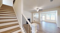 Located at 3900 Salem Road in Covington, Georgia, this two-story home offers a well-designed layout across three bedrooms and three bathrooms. The main floor welcomes you with warm hardwood-style flooring throughout, flowing seamlessly from the staircase entry into the living room, which features a sleek fireplace with a black surround and a ceiling fan overhead. The open sightlines connect the living area to the kitchen, which is appointed with crisp white shaker cabinets, granite countertops, a central island, stainless steel appliances including a French door refrigerator and dishwasher, recessed lighting, and a door providing direct access to the outdoors. The attached garage includes a utility area with a water heater and overhead storage. Upstairs, the spacious primary bedroom offers a generous walk-in closet with built-in wire shelving and hardwood-style flooring. Two additional bedrooms and three full bathrooms — each finished with granite-topped vanities, tub-shower combinations, and clean white fixtures — complete the upper level. Consistent light-toned flooring, neutral white walls, and modern finishes throughout give the home a bright, cohesive aesthetic.