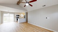 Located at 3422 Cheswick Ct in West Lafayette, Indiana, this single-story, 2-bedroom, 1-bathroom home offers a well-designed layout with a welcoming open-concept living space. The main living and dining area immediately impresses with soaring vaulted ceilings accented by exposed wooden beams and a ceiling fan, all complemented by warm, light-toned hardwood-style flooring that runs throughout the main areas. A large sliding glass door floods the space with natural light and provides outdoor views. The kitchen is thoughtfully appointed with crisp white cabinetry, subway tile backsplash, white quartz countertops, a kitchen island, pendant lighting, and a full suite of stainless steel appliances including a refrigerator, range, microwave, and dishwasher. Both bedrooms offer plush carpeting and ample closet space with sliding panel doors, while the second bedroom features a window with natural light. The full bathroom includes a vanity with white cabinetry, a soaking tub, and wood-look vinyl flooring. Additional highlights include a dedicated laundry area and three closets for generous storage throughout. The neutral color palette and clean finishes create a bright, move-in-ready atmosphere throughout the home.