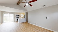 Located at 3422 Cheswick Ct in West Lafayette, Indiana, this single-story, 2-bedroom, 1-bathroom home offers a well-designed layout with a welcoming open-concept living space. The main living and dining area immediately impresses with soaring vaulted ceilings accented by exposed wooden beams and a ceiling fan, all complemented by warm, light-toned hardwood-style flooring that runs throughout the main areas. A large sliding glass door floods the space with natural light and provides outdoor views. The kitchen is thoughtfully appointed with crisp white cabinetry, subway tile backsplash, white quartz countertops, a kitchen island, pendant lighting, and a full suite of stainless steel appliances including a refrigerator, range, microwave, and dishwasher. Both bedrooms offer plush carpeting and ample closet space with sliding panel doors, while the second bedroom features a window with natural light. The full bathroom includes a vanity with white cabinetry, a soaking tub, and wood-look vinyl flooring. Additional highlights include a dedicated laundry area and three closets for generous storage throughout. The neutral color palette and clean finishes create a bright, move-in-ready atmosphere throughout the home.