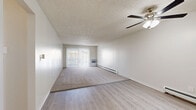 Located at 998 S Miller Way in Lakewood, Colorado, this two-bedroom, two-bathroom residence offers a thoughtfully arranged single-floor layout with a clean, neutral aesthetic throughout. The living room is a bright, open space featuring light wood-style flooring, plush carpet, a ceiling fan with integrated lighting, a textured ceiling, and a sliding glass door that fills the room with natural light and provides access to a private balcony. Baseboard heating runs throughout, ensuring comfortable warmth year-round. The galley-style kitchen is well-appointed with gray shaker cabinetry, granite-style countertops, stainless steel appliances including a refrigerator, range, and dishwasher, and a window that brings in additional natural light. Both bedrooms are carpeted and comfortably sized, each featuring a ceiling fan, closet storage, and windows. The primary bedroom includes ample closet space. Four closets in total provide generous storage throughout the unit. The two bathrooms are finished with light wood-style flooring and white vanities; one features a walk-in glass-door shower alongside a built-in shelving closet. Connecting hallways offer a smooth flow between living and private spaces, completing this well-organized and functional Lakewood residence.