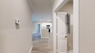 This well-appointed two-bedroom, two-bathroom home in Tallahassee, FL offers a thoughtfully designed single-floor layout with modern finishes throughout. Light-toned luxury vinyl plank flooring flows through the main living areas, anchored by a bright, open-concept kitchen and living room. The kitchen features white cabinetry, stainless steel appliances including a refrigerator and range, pendant lighting over a center island with a sink, and light-colored countertops that complement the clean aesthetic. The living room is highlighted by a corner fireplace framed in white trim, crown molding, and a window that welcomes natural light. A connecting hallway provides access to both bedrooms, each carpeted for comfort and equipped with ceiling fans and windows. The spacious primary bedroom includes double doors leading to a dedicated walk-in closet with built-in wire shelving. The second bedroom is equally well-sized with its own ceiling fan. Both bathrooms feature a tub/shower combination, white vanity cabinetry, and brushed nickel fixtures. A dedicated laundry room with washer/dryer hookups and overhead shelving adds everyday convenience, rounding out this functional and inviting home.