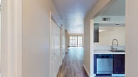 Located at 9375 N Saybrook Dr in Fresno, CA, this two-story, 3-bedroom, 3-bathroom home offers a well-designed layout spread evenly across two floors. The main level features an open living room with warm hardwood-style flooring, a tile-surround fireplace, and a sliding glass door that fills the space with natural light and provides outdoor access. The kitchen is outfitted with rich dark wood cabinetry, light stone countertops, and a full suite of stainless steel appliances including a refrigerator, range, microwave, and dishwasher. A pass-through window connects the kitchen to the living area, enhancing the open feel. Upstairs, the generously sized primary bedroom boasts soaring vaulted ceilings, plush carpeting, a ceiling fan, and an en-suite bathroom with vanity and mirror. A walk-in closet with built-in shelving and hanging rods provides ample storage. The additional bedrooms are carpeted and well-lit by natural light. All three bathrooms feature hardwood-style flooring and tub-shower combinations with sliding glass enclosures. Hallways connect each floor's rooms efficiently, and a carpeted staircase links both levels. The home presents a clean, neutral palette throughout, creating a bright and inviting atmosphere.