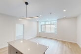 Located in the heart of downtown Calgary on 8th Avenue SW, this well-appointed 3-bedroom, 2-bathroom unit offers a thoughtfully designed single-level layout. Light hardwood flooring flows consistently throughout the space, complementing the clean white walls and modern finishes that define the interior aesthetic.

The open-concept kitchen is a standout feature, equipped with warm wood cabinetry, grey lower cabinets, stainless steel appliances, a white subway tile backsplash, and a central island with a pendant light overhead — ideal for both cooking and casual dining. The adjacent living area is bright and airy, benefiting from large windows that frame views of the surrounding Calgary skyline.

Each of the three bedrooms is well-proportioned, with the primary bedroom offering generous closet space and large windows overlooking the urban landscape. The unit also includes four closets in total, providing ample storage throughout.

Both bathrooms are finished to a high standard, featuring marble-look tile surrounds in the tub/shower combinations, matte black fixtures, grey floating vanities, and illuminated mirrors — creating a sleek, contemporary feel. A dedicated laundry area and two connecting hallways with recessed lighting round out this functional and stylish urban residence.