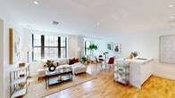 Located in the vibrant Lanier Heights neighborhood of Washington, DC, this thoughtfully designed residence offers a seamless blend of modern finishes and functional living. The open-concept main area unites the living room, dining space, and kitchen into a single cohesive zone, bathed in natural light streaming through large black-framed windows that frame views of the surrounding urban streetscape. Warm hardwood flooring runs throughout, adding continuity and a welcoming tone to the space.

The living area provides a comfortable gathering space, while the dedicated dining nook accommodates a full table and chairs beneath additional windows. The sleek, galley-style kitchen features crisp white cabinetry, a generous white quartz countertop island, stainless steel appliances including a gas range, and recessed lighting — combining style with practicality.

The bedroom is a calm, light-filled retreat with a large window, ample closet storage, and clean white walls. Two closets ensure generous storage throughout the residence. The bathroom is finished with large-format tile flooring, a floating white vanity, a full-width mirror, and warm wood accent tiling, achieving a clean, spa-like aesthetic. Every detail of this well-appointed home reflects a commitment to modern, comfortable urban living.