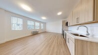 Located at 11 1st Ave in Bay Shore, NY, this thoughtfully designed one-bedroom, one-bathroom unit offers a clean, modern aesthetic throughout. Light-toned luxury vinyl plank flooring flows seamlessly across the entire space, creating a bright and cohesive feel.

The open-concept living and kitchen area forms the heart of the unit. The kitchen is outfitted with light wood cabinetry, a white quartz countertop, white subway tile backsplash, and a full suite of stainless steel appliances including a refrigerator, range, built-in microwave, and dishwasher. A stainless steel sink with a modern arc faucet completes the functional workspace.

The living area is generously proportioned, featuring a bank of windows fitted with horizontal blinds that allow ample natural light while maintaining privacy. A wall-mounted HVAC unit provides climate control.

The bedroom is a comfortable, well-sized room with its own window and wall thermostat, offering a quiet retreat. A shaker-style closet door adds a refined architectural detail.

The bathroom is finished with a light wood vanity, white quartz countertop, framed mirror, and a full tub/shower combination surrounded by clean white subway tile and chrome fixtures. The overall ambiance is fresh, modern, and move-in ready.