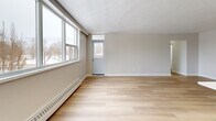 Located at 1231 Richmond St in London, Ontario, this well-appointed 2-bedroom, 2-bathroom unit offers a thoughtfully designed open-concept layout finished with light hardwood flooring throughout. The combined living and dining area is generously sized, bathed in natural light from a wide bank of windows that frame views of the surrounding neighbourhood's mature trees and streetscape.

The modern kitchen is a standout feature, equipped with stainless steel appliances including a refrigerator, stove, and microwave, complemented by light wood cabinetry, grey tile backsplash, and a large central island with a clean white countertop — ideal for both meal preparation and casual dining.

The spacious primary bedroom includes direct access to a dedicated bathroom, providing added privacy and convenience. The second bedroom is equally well-lit, with large windows and baseboard heating. Both bathrooms are finished with contemporary fixtures, light wood vanities, and one features a full soaker tub with elegant subway tile surround.

Additional highlights include four closets offering ample storage, a hallway connecting all rooms efficiently, a private balcony, and a welcoming entrance. The unit's clean, neutral palette and modern finishes create a bright, functional living environment.