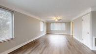 This single-story, 4-bedroom, 2-bathroom home offers a thoughtfully designed layout that maximizes functionality and comfort. The welcoming entrance opens into a spacious living room featuring light hardwood-style flooring, soft neutral walls, and a ceiling fan, with multiple windows that invite ample natural light. The kitchen is outfitted with crisp white shaker cabinets, marble-look countertops, and stainless steel appliances, including a range and over-the-range microwave, all set over warm hardwood-style flooring. Two hallways connect the living areas to the private quarters, where four bedrooms provide generous accommodations. The primary bedroom is notably spacious, featuring hardwood-style flooring, large windows, and a ceiling fan, while the remaining bedrooms are carpeted and each include a window with blinds and closet space. The two bathrooms are finished with clean white subway tile, white vanities with brushed nickel fixtures, framed mirrors, and hardwood-style flooring. One bathroom features a full tub-shower combination, while the second includes a tiled shower. Throughout the home, a consistent neutral palette, clean white trim, and modern finishes create a cohesive, move-in-ready aesthetic.