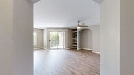 This single-story residence spans 1,060 square feet and features 4 bedrooms, 2 bathrooms, 2 closets, a hallway, and a dedicated entrance. Throughout the unit, light wood-tone laminate flooring and neutral gray walls create a clean, cohesive aesthetic.

The open kitchen and living area serve as the heart of the home. The kitchen is equipped with stainless steel appliances — including a range, microwave, dishwasher, and refrigerator — complemented by white shaker cabinetry, light quartz countertops, a chevron-patterned tile backsplash, and track lighting overhead. The living room receives ample natural light and features sliding glass doors that open to a private balcony with outdoor views, alongside built-in shelving for additional storage and display.

The primary bedroom measures 180 square feet and includes a ceiling fan, access to a closet, and a dedicated en-suite bathroom. The primary bath features a double-sink vanity with white cabinetry and quartz countertops, a soaking tub, and a tiled shower surround. The secondary bathroom mirrors a similar clean design with a single vanity and tub-shower combination. Additional bedrooms are well-sized with ceiling fans and ample closet space, including a spacious walk-in closet with wire shelving.