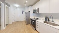 Located at 1326 Florida Ave NE, Unit 103 in Washington, DC, this one-bedroom, one-bathroom residence offers a well-designed layout across a single floor. The open kitchen is outfitted with sleek white cabinetry, white quartz countertops, and a full suite of stainless steel appliances including a range, over-the-range microwave, dishwasher, and refrigerator. Light wood-style flooring runs throughout the main living areas, contributing to a bright and cohesive aesthetic. The living space flows naturally from the kitchen, providing a comfortable area for relaxing or entertaining. A dedicated office room offers a quiet, separate space ideal for remote work or creative pursuits. The bedroom is a cozy retreat featuring a window with views to the outdoors, a closet for storage, and warm, neutral tones that create a restful ambiance. The bathroom is clean and modern, featuring a shower/tub combination with a stylish curtain, a white vanity, and tile flooring. A dedicated closet provides additional storage. The unit's efficient and functional design makes excellent use of its footprint, making it a practical choice in the heart of Washington, DC.