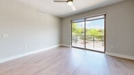 Located at 1120 Shady Ln in Austin, TX, this well-designed 2-bedroom, 3-bathroom unit offers a thoughtfully laid-out single-floor plan with a clean, contemporary aesthetic throughout. Light wood-style flooring flows seamlessly across every room, complementing a neutral palette of soft grays and whites that creates a bright, cohesive atmosphere.

The open-concept kitchen and living area serves as the heart of the unit, featuring a large central island with ample drawer storage and a white quartz countertop. Stainless steel appliances, including a French door refrigerator, electric range, microwave, and dishwasher, are paired with white upper cabinetry and gray lower cabinets. A tile backsplash and stylish black pendant lights add modern character, while recessed lighting ensures the space is well-illuminated.

Both bedrooms are generously proportioned, with the primary bedroom offering a walk-in closet equipped with built-in shelving and direct access to a private en-suite bathroom. The bathrooms are finished with gray cabinetry, white countertops, and modern brushed nickel fixtures. A second walk-in closet provides additional storage convenience.

Bedroom windows frame views of the surrounding mature tree canopy, bringing natural light and a serene outdoor connection into the living spaces.
