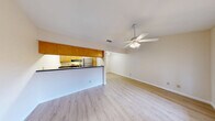 Located at 8615 Rockwood Ln in Austin, TX, this single-story, one-bedroom, one-bathroom home offers a well-organized layout that makes smart use of its cozy footprint. Light wood-style flooring flows consistently throughout, lending warmth and visual continuity to every room.

The combined kitchen and living area serves as the heart of the home. The living space is bright and open, with two large windows fitted with blinds that invite generous natural light, complemented by a ceiling fan overhead. The kitchen is positioned behind a raised bar-height peninsula with a dark countertop, creating a natural separation between cooking and living areas. Warm honey-toned wood cabinetry lines the kitchen walls, with overhead cabinets extending to the ceiling for ample storage. A stainless refrigerator and range complete the space.

The bedroom is comfortably sized, featuring the same light wood flooring, a ceiling fan with light kit, and a wide double-door closet offering generous storage. Multiple windows frame views of the surrounding brick exterior and greenery outside.

The full bathroom includes a soaking tub and shower combination with clean white tile surround, brushed nickel fixtures, and a wood-toned vanity cabinet. A hallway connects the rooms, completing this practical and pleasant single-floor layout in a well-established Austin neighborhood.