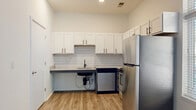 Located at 815 Kinnear Rd. in Columbus, Ohio, this one-bedroom, one-bathroom unit offers a thoughtfully designed single-floor layout that maximizes every square foot. Light wood-tone flooring runs throughout, creating a cohesive and clean aesthetic from room to room.

The open living area is bright and airy, featuring crisp white walls and multiple windows dressed with blinds that allow abundant natural light to fill the space. The kitchen is a standout, outfitted with white shaker-style cabinetry, dark hardware accents, granite-look countertops, and a striking hexagonal tile backsplash. A full suite of stainless steel appliances — including a refrigerator, electric range, over-the-range microwave, and dishwasher — completes the functional and stylish kitchen.

The bedroom is a comfortable, well-proportioned retreat with its own window providing natural light and a dedicated closet for storage. The bathroom is designed with accessibility in mind, featuring grab bars alongside a walk-in shower with large-format marble-style tile, wood-look flooring, and a clean, minimal finish.

Overall, the unit presents a modern, move-in-ready environment with consistent finishes and practical design throughout, suitable for comfortable everyday living.