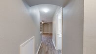 This well-appointed 960-square-foot apartment offers a functional single-floor layout with 2 bedrooms and 2 bathrooms. The open living room is highlighted by wood-look vinyl flooring, neutral gray walls, a ceiling fan, built-in shelving, an arched architectural detail, and a sliding glass door that brings in abundant natural light. The kitchen features stainless steel appliances—including a refrigerator, range, and microwave—white cabinetry, a quartz-topped peninsula with a double sink, track lighting, and a decorative wine rack. Both bedrooms are carpeted and equipped with ceiling fans and windows overlooking greenery. The primary bedroom measures 160 square feet and includes access to a walk-in closet fitted with wire shelving. Both bathrooms share a consistent design with wood-look flooring, white vanities with quartz countertops, white cabinetry, and a tub/shower combo with tile surround. A dedicated in-unit laundry room houses a full-size top-loading washer and dryer. Two hallways and two additional closets enhance storage and circulation throughout the unit, making this apartment a practical and comfortable living space.