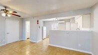 Located at 3201 Laura Koppe Rd in Houston, TX, this single-floor unit offers a practical and efficiently designed layout comprising a living room, kitchen, bathroom, and closet. The living room serves as the welcoming heart of the space, featuring warm tan tile flooring that extends throughout the unit, a ceiling fan with light fixture, and two windows flanking the front entry door that allow natural light to fill the room. The open layout creates a seamless flow from the living area toward the kitchen. The kitchen is well-appointed with white cabinetry, a classic white subway tile backsplash, a gas range, a refrigerator, and a stainless steel sink. A wall-mounted mini-split air conditioning unit provides climate control, complemented by a baseboard heating system. Track lighting illuminates the kitchen workspace effectively. A dedicated closet provides convenient built-in storage. The bathroom includes a full tub-shower combination with white tile surround, a toilet, and a window for ventilation. Neutral gray walls are consistent throughout the space, creating a clean and cohesive aesthetic. The unit is also equipped with a fire extinguisher for safety. Overall, the space offers a straightforward and functional design suitable for everyday living.