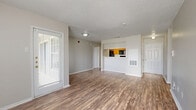 Located at 4035 Towne Crossing Blvd in Mesquite, TX, this single-floor, 2-bedroom, 3-bathroom residence offers a practical and comfortable layout. The open living area greets you with warm wood-look hardwood flooring, neutral-toned walls, and a textured ceiling, while multiple windows fitted with blinds allow generous natural light to fill the space. A pass-through counter connects the living room to the kitchen, which features warm wood cabinetry, light speckled countertops, a double sink, and black appliances including a refrigerator and electric range. A dedicated pantry or storage closet is conveniently accessible directly from the kitchen. The two bedrooms are carpeted and well-proportioned, with the primary bedroom offering a comfortable retreat complete with a closet and natural light from a window with vertical blinds. Each bedroom benefits from its own access to a bathroom, with the bathrooms featuring clean white tile tub-shower combinations. Two closets throughout the unit provide additional storage. The overall ambiance is clean, functional, and move-in ready, presenting a well-organized floor plan suited for everyday living.