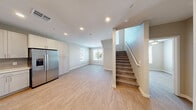 Located at 1639 E Tropicana Ave in Las Vegas, NV, this two-story residence offers 3 bedrooms, 3 bathrooms, and a thoughtfully designed layout spread across two floors. The main level features an open-concept living and kitchen area finished with light wood-look flooring and recessed lighting throughout. The kitchen is well-appointed with white shaker cabinetry, a subway tile backsplash, quartz countertops, a stainless steel refrigerator with ice maker, dishwasher, range, and built-in microwave. Natural light flows in through windows, complementing the clean, neutral color palette. A staircase with a wood handrail connects the main level to the upper floor, where the bedrooms are located. Each bedroom features light flooring, neutral walls, and ample natural light, with dedicated closets providing generous storage. All three bathrooms are finished consistently with white vanities, tiled tub-shower combinations, and chrome fixtures. A dedicated laundry area houses a stacked full-size washer and dryer, adding everyday convenience. With three closets distributed throughout the home, storage is plentiful. The space presents a clean, modern aesthetic well-suited for comfortable living in the heart of Las Vegas.