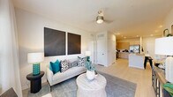 Located at 1105 Grassy Lake Dr in Davenport, FL, this well-designed 2-bedroom, 3-bathroom residence offers a thoughtfully planned single-level layout. The open-concept kitchen flows seamlessly into the living area, anchored by a central island with bar seating and an undermount sink — ideal for both everyday meals and entertaining. The kitchen is outfitted with flat-front cabinetry in a warm taupe finish, a subway tile backsplash, white quartz countertops, and a full suite of stainless steel appliances. Light wood-style flooring runs throughout the main living areas, enhancing the bright, airy ambiance. The living room features a ceiling fan and receives generous natural light. Both bedrooms are comfortably sized — the primary bedroom is notably spacious — and each features large windows with outdoor views, ceiling fans, and dedicated closets with wire shelving systems for organized storage. The three bathrooms are finished with clean, modern fixtures; bathrooms include floating vanities with white countertops and tub-shower combinations clad in large-format marble-look tile with brushed gold hardware. The overall aesthetic is contemporary and cohesive, with a neutral palette throughout.